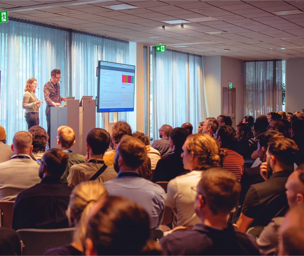 previous Svelte summit, with audience members listening to a talk